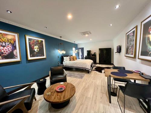 a living room with a bed and a table and chairs at Forty 4 On Hoog in Polokwane