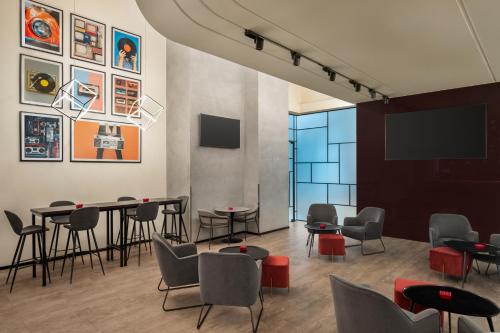 a waiting room with tables and chairs and a flat screen tv at ibis Dubai Al Rigga in Dubai