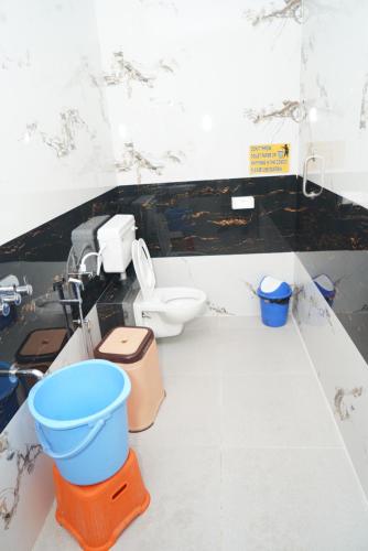 a bathroom with a toilet and a sink at Ranjana Guesthouse in Hampi
