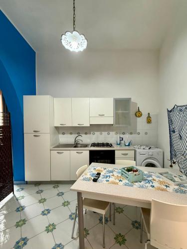 a kitchen with white cabinets and a table at Monolocale Poseidonea in Favignana