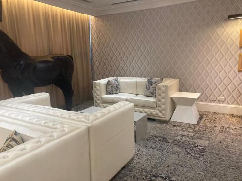 a living room with two white couches and a horse statue at 56th Floor - Makati View - Knightsbridge Residences in Manila