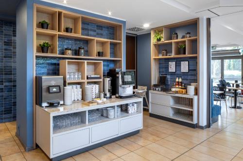 a coffee shop with a counter and a room at Hotel Oliwski in Gdańsk