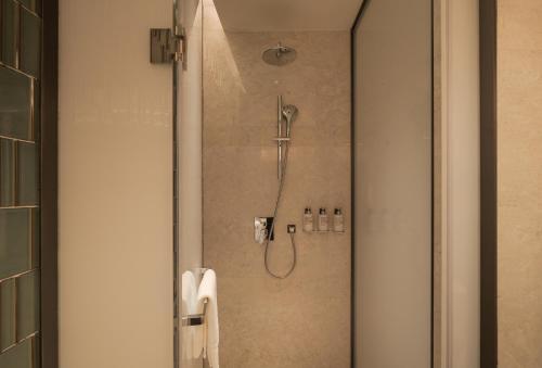 a shower with a glass door with a shower at Chengdu Expo Waterfall Hotel - MGallery Collection in Chengdu