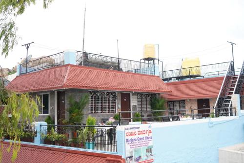 a building with a red roof with a sign in front of it at Ranjana Guesthouse in Hampi