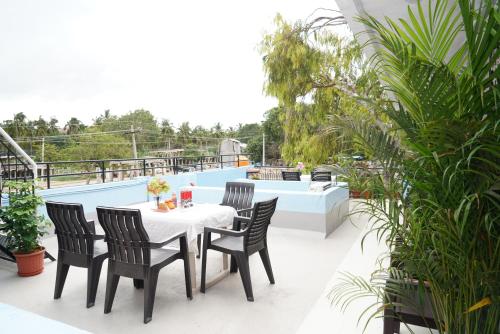 a table and chairs on a balcony with a pool at Ranjana Guesthouse in Hampi