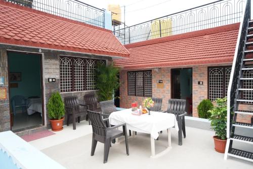 a patio with a white table and chairs at Ranjana Guesthouse in Hampi