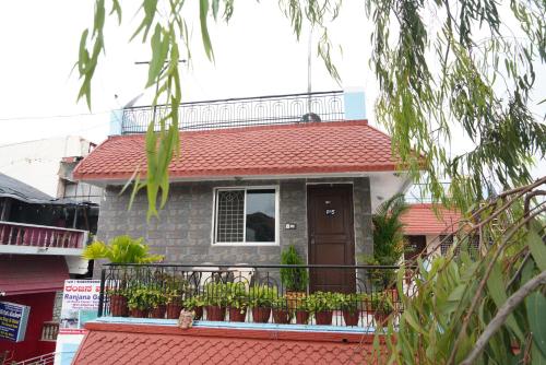 a house with a balcony with plants on it at Ranjana Guesthouse in Hampi