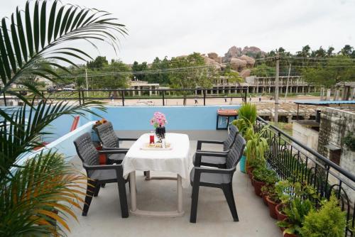 a patio with a table and chairs on a balcony at Ranjana Guesthouse in Hampi