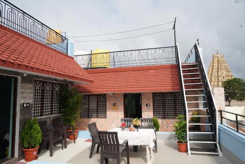 a patio with a table and chairs on a building at Ranjana Guesthouse in Hampi