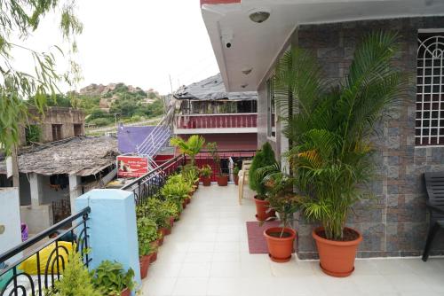 a balcony with plants in pots on a building at Ranjana Guesthouse in Hampi