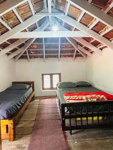 a room with two beds and a ceiling with beams at Coffee grove homestay in Chikmagalūr