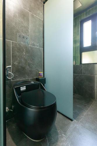 a bathroom with a black tub and a shower at TA Hotel - Hue City Center in Hue