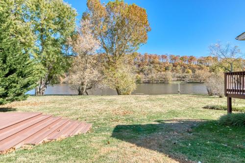 a park with a bench next to a river at New River 3BR - Fishing, Hot Tub and VT Game Weekends in Radford