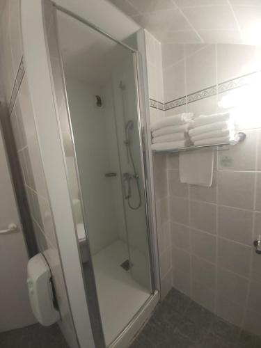 a shower in a bathroom with white towels at ibis Styles Bourg-en-Bresse Centre in Bourg-en-Bresse