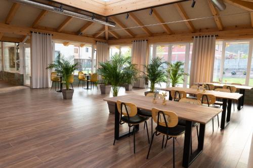 a restaurant with wooden tables and chairs and plants at Pardavila 57 Slow Hotel in Marín