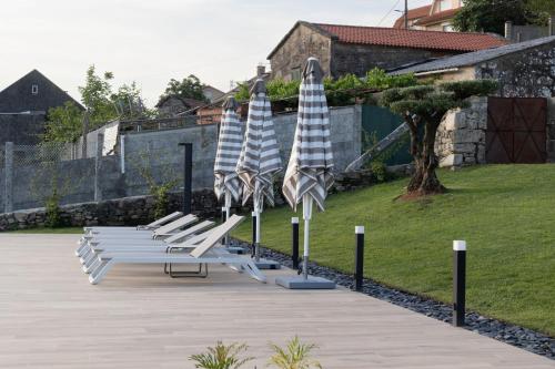 a row of blue and white umbrellas and lounge chairs at Pardavila 57 Slow Hotel in Marín
