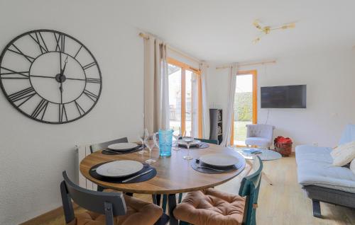 a dining room with a table and a clock on the wall at Jolie Maison Avec Terrasse in Le Crotoy
