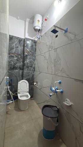 a bathroom with a toilet and a trash can at Jhankar home stay in Ujjain