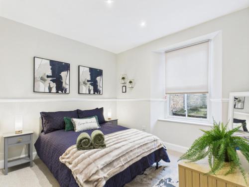 a bedroom with a bed with two shoes on it at The Quirky Townhouse, Hawick in Hawick
