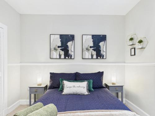 a bedroom with a bed with three pictures on the wall at The Quirky Townhouse, Hawick in Hawick