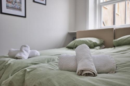 two rolls of towels on top of two beds at The Coastal Hideaway in Deal