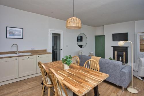 a kitchen and living room with a table and a couch at The Coastal Hideaway in Deal
