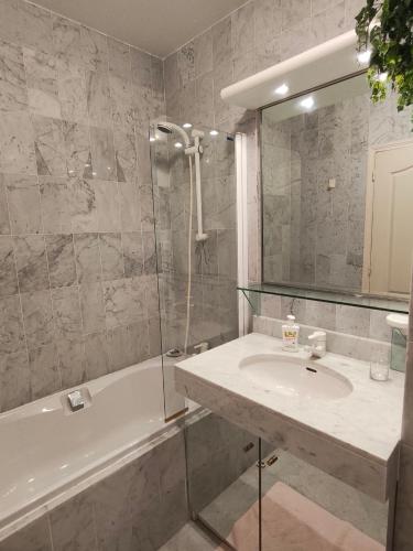 une salle de bain avec un lavabo, une baignoire et une douche dans l'établissement Victoria Sea, à Menton