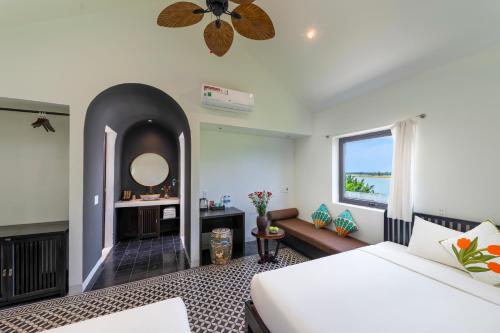 a hotel room with a bed and a window at Hoianoi Villa_A Little Hoi An_Entire villa in Hoi An