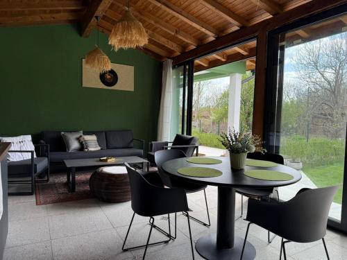 ein Wohnzimmer mit Tisch und Stühlen in der Unterkunft Villa Green House in Tscherweni Breg