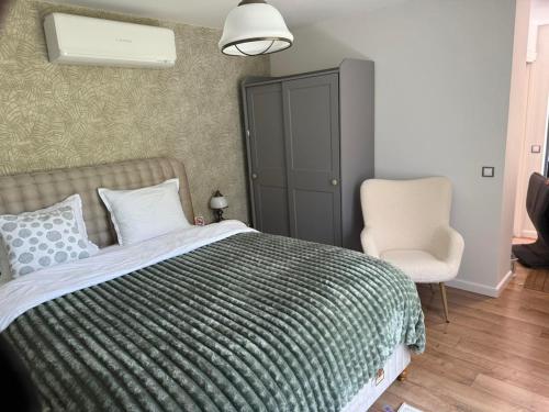 ein Schlafzimmer mit einem Bett und einem Stuhl in der Unterkunft Villa Green House in Tscherweni Breg