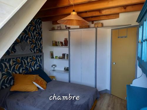 a small bedroom with a bed and a cabinet at Au Numéro 20 in Tournon-Saint-Pierre