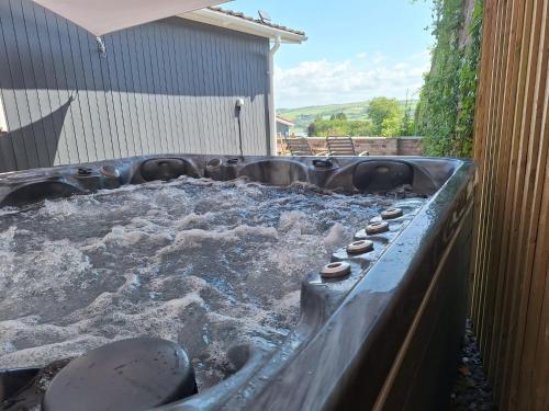 a hot tub filled with water in a backyard at Eden Garden in Llangain