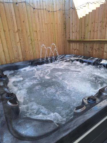 a hot tub with snow and water in a fence at Eden Garden in Llangain