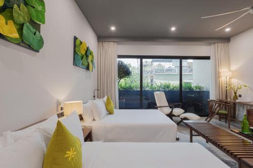 a hotel room with two beds and a balcony at TA Hotel - Hue City Center in Hue