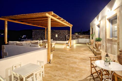 a rooftop patio with tables and chairs at night at Blue Bay Patmos Summer House in Grikos
