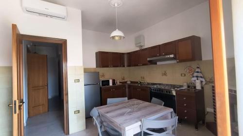 a kitchen with a table and a small kitchen with brown cabinets at L'Imperiale Granaio Casa Vacanze in Rocca Imperiale