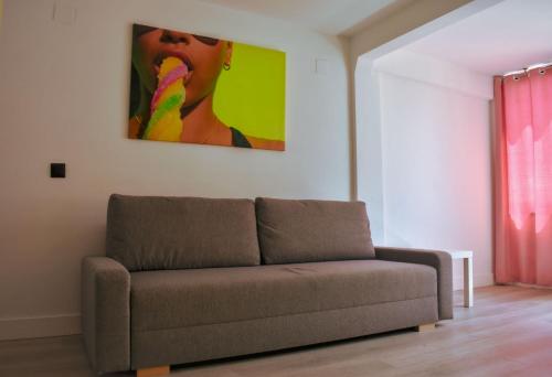a couch in a living room with a painting on the wall at Now Benidorm in Benidorm
