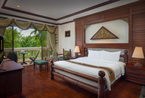 a bedroom with a bed and a large window at Borei Angkor Resort & Spa in Siem Reap