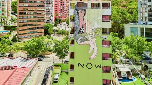 a building with a painting of a woman on it at Now Benidorm in Benidorm