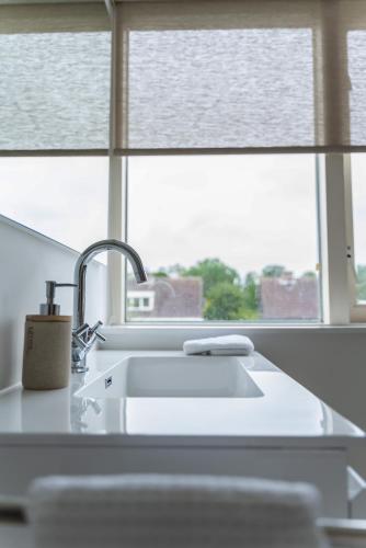 a kitchen counter with a sink and a window at - Het Kleine Nest - nabij het meer, strand & Keukenhof in Noordwijkerhout
