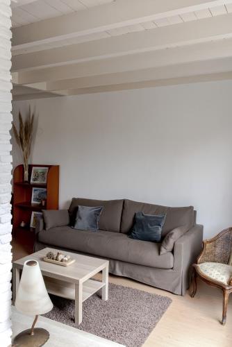 a living room with a couch and a coffee table at - Het Kleine Nest - nabij het meer, strand & Keukenhof in Noordwijkerhout