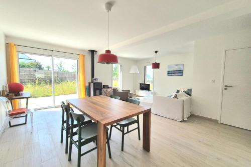 a living room with a wooden table and chairs at Superb house with garden - Saint-Coulomb in Saint-Coulomb