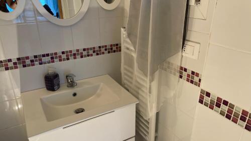 Un baño blanco con lavabo y ducha. en Argentina home VERRANDI, en Trucco