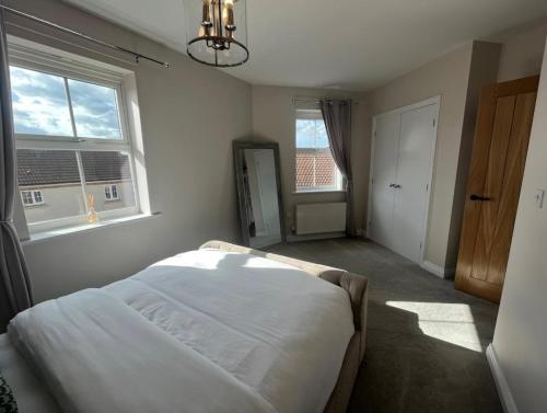 a bedroom with a bed and two windows at 2 bed apartment Moulton Park in Spinney Hill