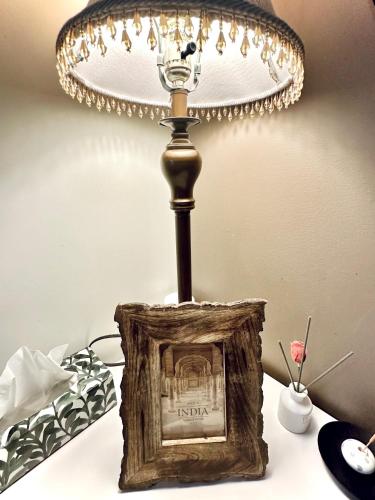 a lamp on top of a table with a picture at Scorpion Hiuse Langley ROOM B in Langley
