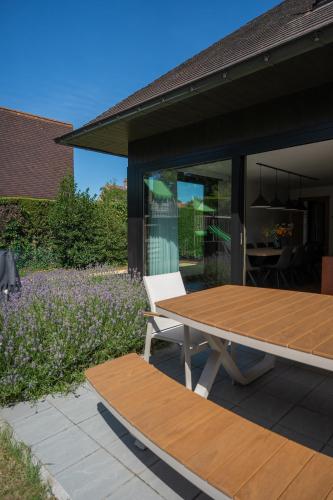 a picnic table and a bench on a patio at Villa Marsel Oostduinkerke in Oostduinkerke