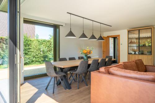 a dining room and living room with a table and chairs at Villa Marsel Oostduinkerke in Oostduinkerke