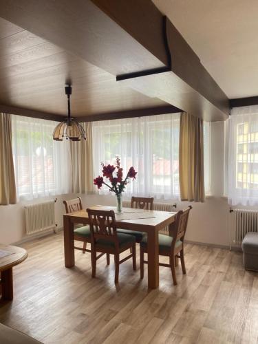 a dining room with a table and chairs and flowers at Alpenpension Haslinger in Bad Gastein