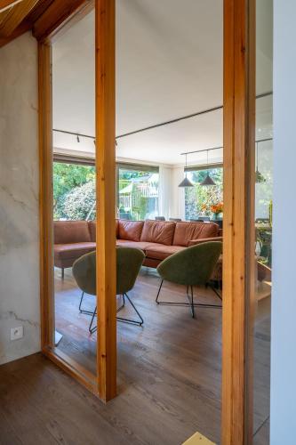 a living room with a couch and a mirror at Villa Marsel Oostduinkerke in Oostduinkerke