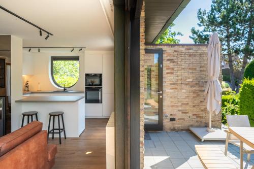 an open kitchen and living room with a brick wall at Villa Marsel Oostduinkerke in Oostduinkerke